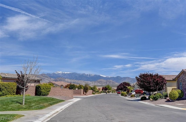 view of road with sidewalks, curbs, and a mountain view