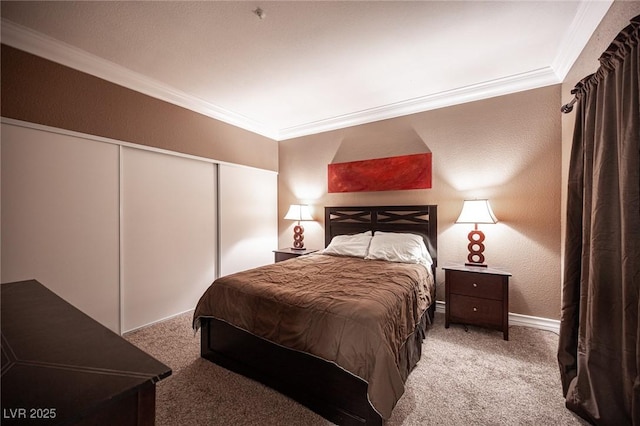 bedroom featuring a textured wall, a closet, carpet, and ornamental molding