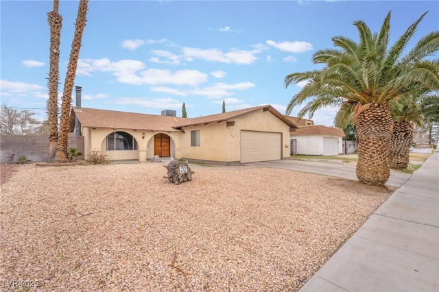 ranch-style house with stucco siding, driveway, a garage, and fence