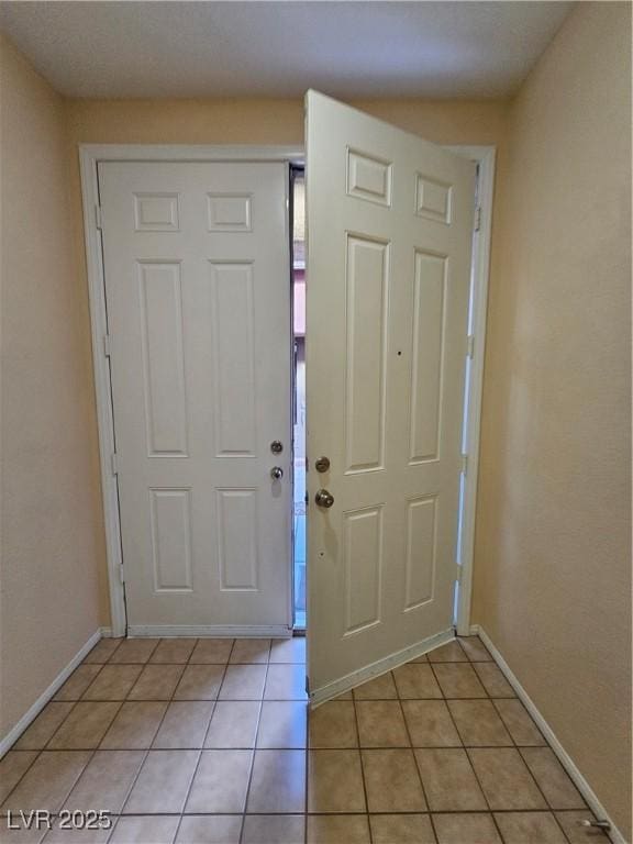 foyer entrance with baseboards and light tile patterned flooring