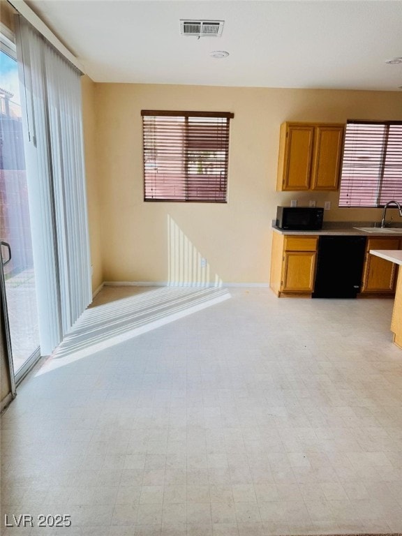 kitchen with visible vents, light floors, dishwasher, light countertops, and a sink