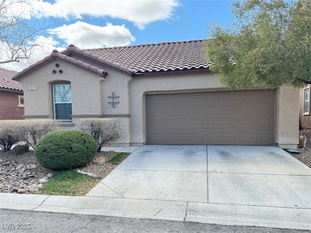 mediterranean / spanish house with stucco siding, concrete driveway, a tile roof, and an attached garage