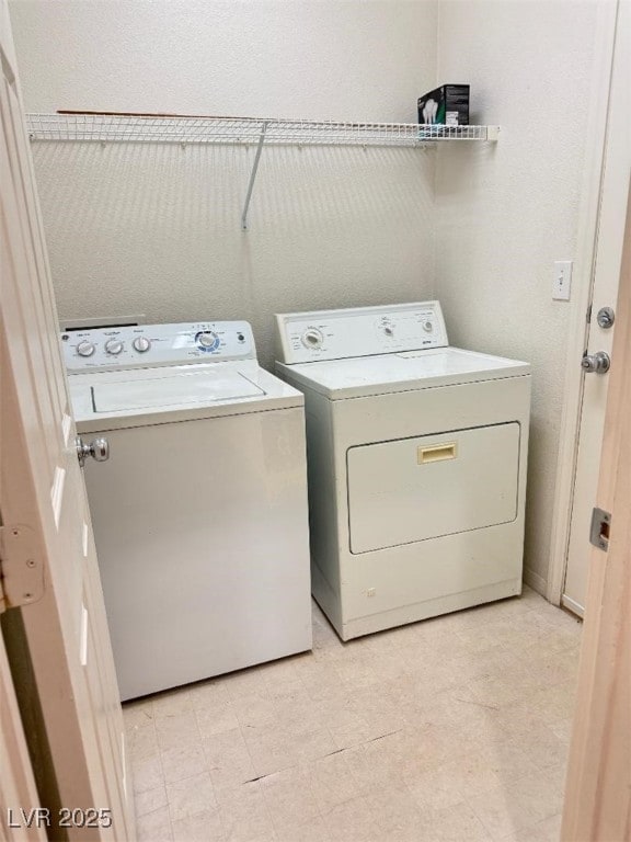 clothes washing area featuring laundry area, washer and dryer, and light floors