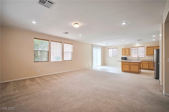7317 Caballo Range Ave, Las Vegas, NV 89179 - unfurnished living room with light carpet, baseboards, recessed lighting, and a sink