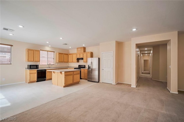 7317 Caballo Range Ave, Las Vegas, NV 89179 - kitchen with black appliances, a sink, light brown cabinetry, light countertops, and a kitchen island