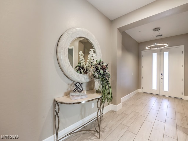 foyer entrance featuring visible vents, baseboards, french doors, and light wood-type flooring