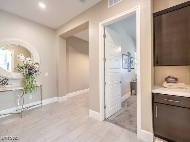 corridor with visible vents, recessed lighting, baseboards, and light wood-type flooring