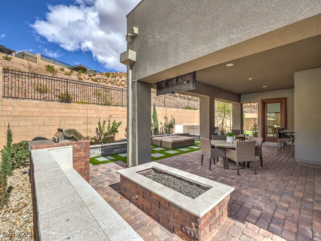 view of patio / terrace with outdoor dining space, a fire pit, and a fenced backyard