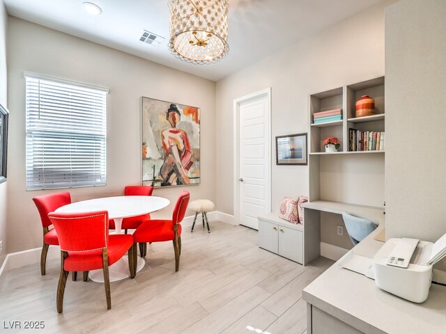 dining space with a chandelier, visible vents, light wood-style flooring, and baseboards