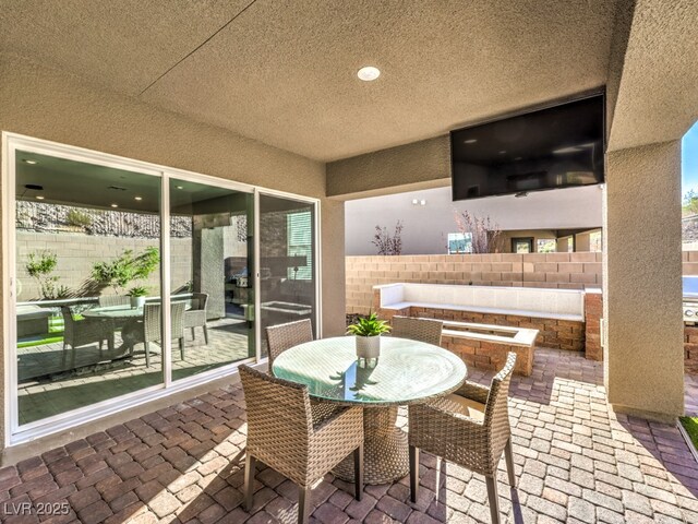 view of patio featuring outdoor dining area and fence