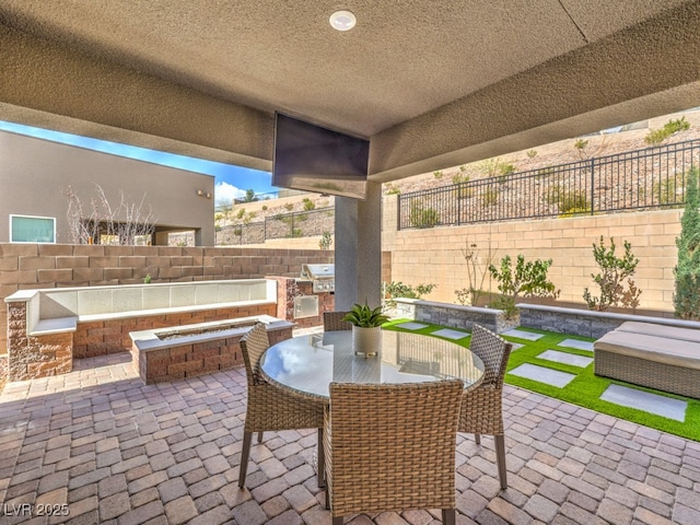 view of patio with area for grilling, outdoor dining area, a fenced backyard, a fire pit, and a grill