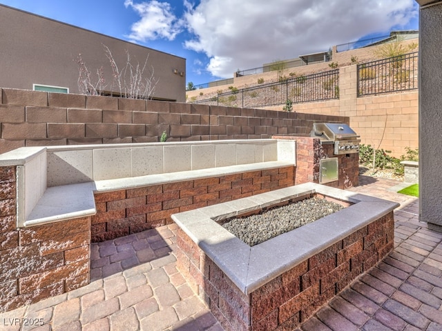 view of patio / terrace with a grill, a fire pit, and fence