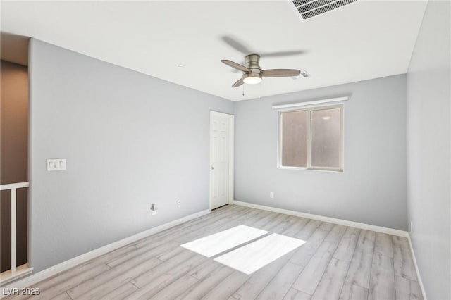 spare room featuring visible vents, baseboards, wood finished floors, and a ceiling fan