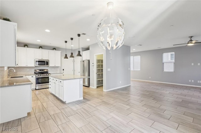 kitchen featuring a sink, tasteful backsplash, open floor plan, and stainless steel appliances