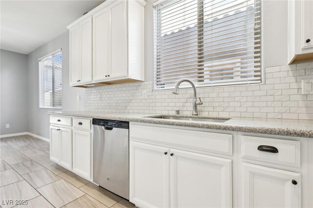 kitchen with a sink, backsplash, dishwasher, and white cabinets