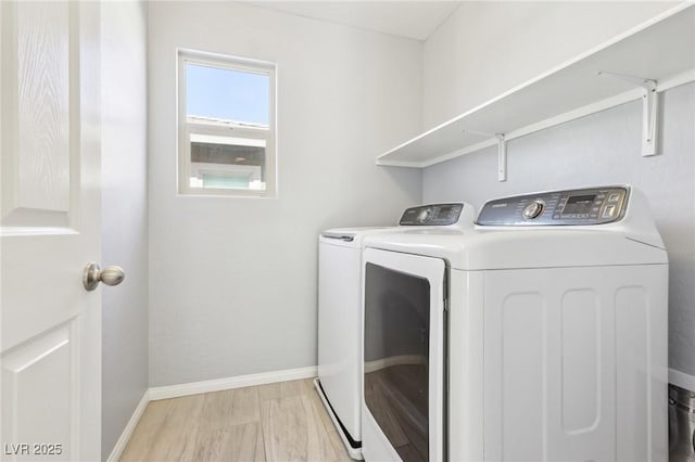 laundry area featuring baseboards, light wood-style flooring, laundry area, and washing machine and clothes dryer