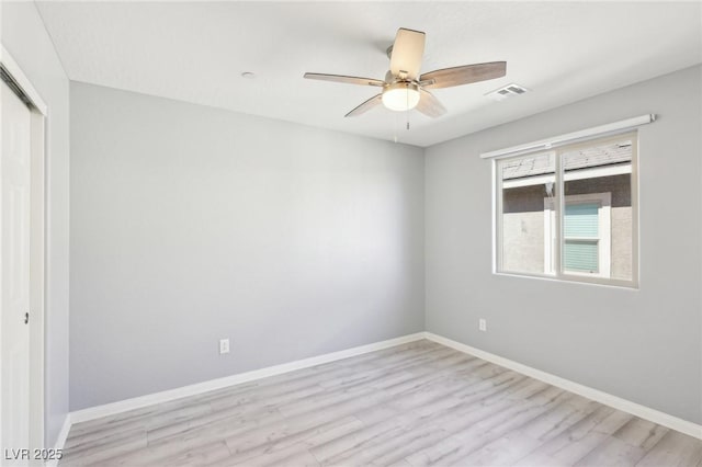 spare room with visible vents, baseboards, and wood finished floors