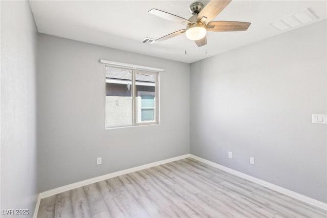 spare room featuring wood finished floors, baseboards, and visible vents