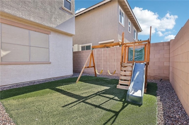 view of play area with a lawn and a fenced backyard