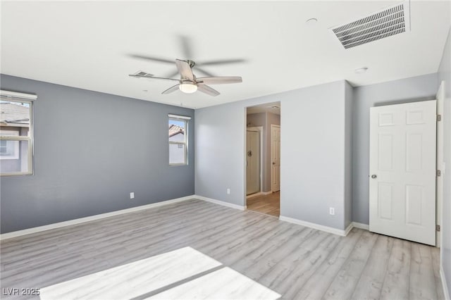 unfurnished bedroom featuring ceiling fan, baseboards, visible vents, and light wood-type flooring