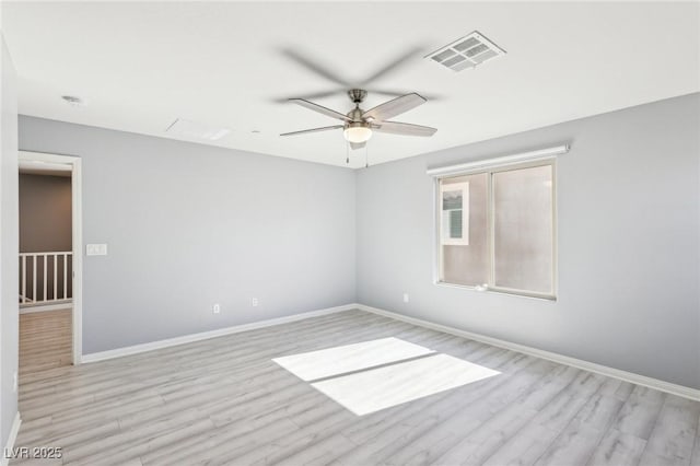 spare room featuring visible vents, baseboards, light wood-style floors, and a ceiling fan