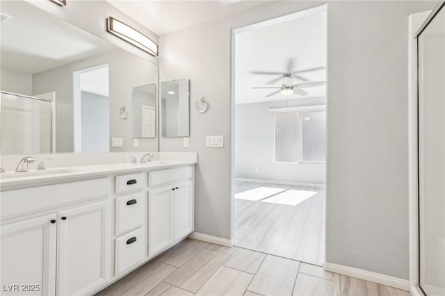 full bath with a ceiling fan, a shower with shower door, and a sink