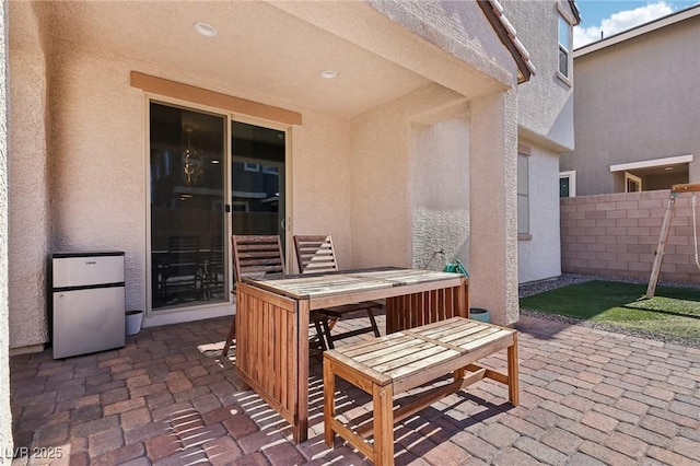 view of patio featuring outdoor dining area and fence