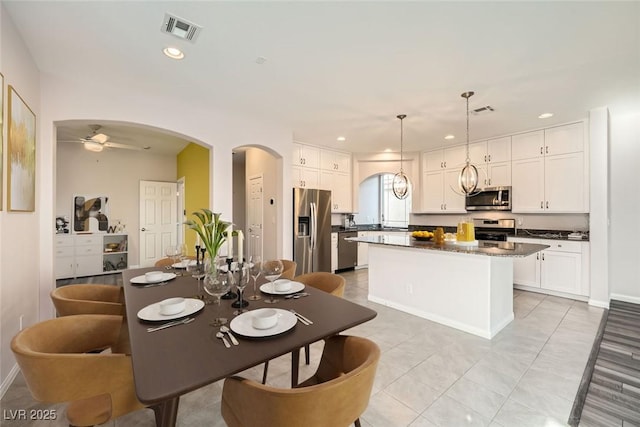 dining room featuring recessed lighting, visible vents, arched walkways, and ceiling fan