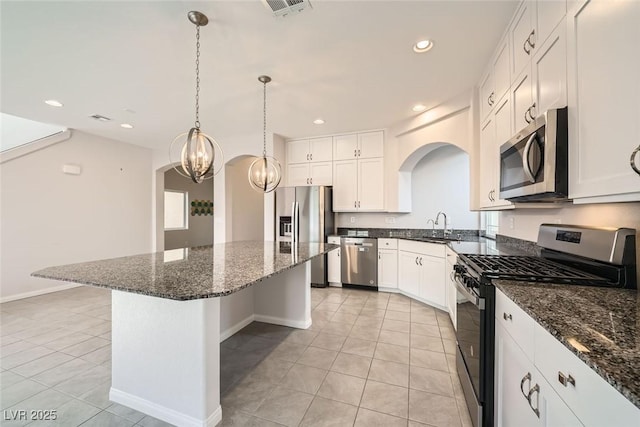 kitchen featuring a center island, recessed lighting, light tile patterned flooring, white cabinets, and stainless steel appliances