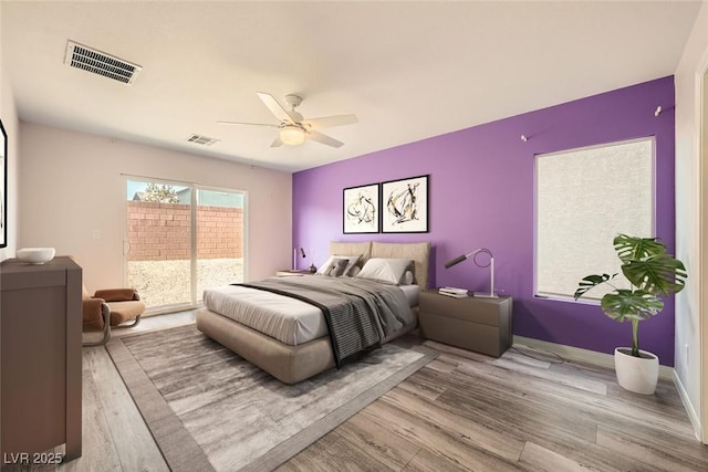 bedroom with access to exterior, wood finished floors, and visible vents