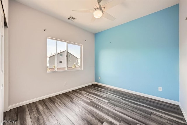 spare room with visible vents, baseboards, wood finished floors, and a ceiling fan