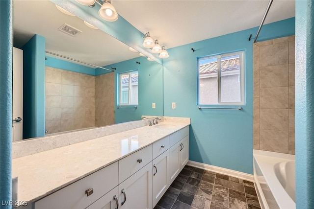 bathroom featuring visible vents, a bathing tub, baseboards, walk in shower, and vanity