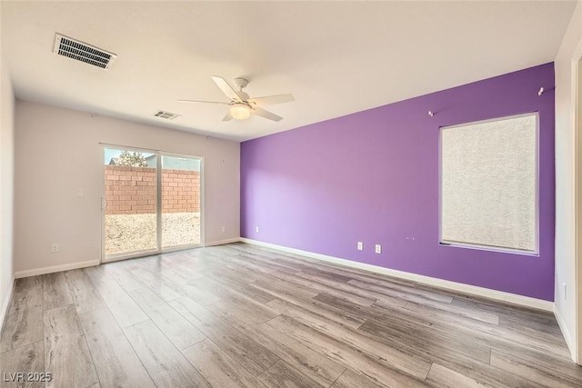 unfurnished room with visible vents, baseboards, and wood finished floors