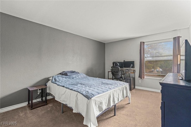 bedroom featuring baseboards, carpet, and a textured wall