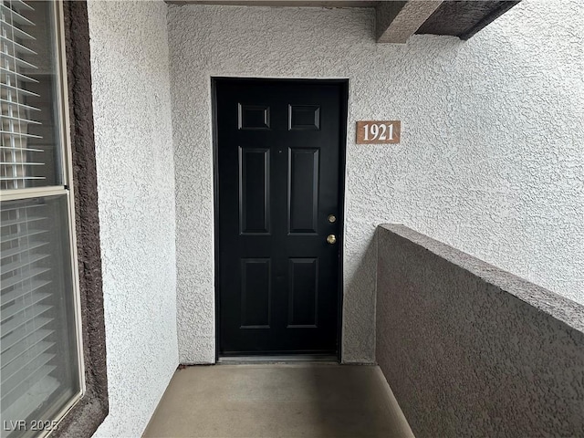 property entrance with stucco siding