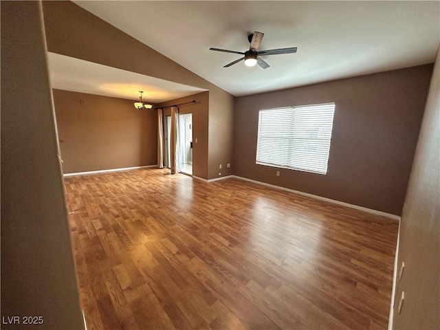 spare room featuring ceiling fan, baseboards, lofted ceiling, and wood finished floors