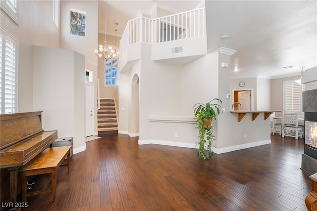 entrance foyer with stairway, visible vents, baseboards, and wood-type flooring