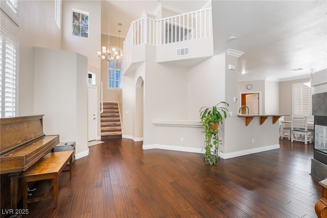 foyer entrance with hardwood / wood-style floors, stairway, visible vents, and baseboards