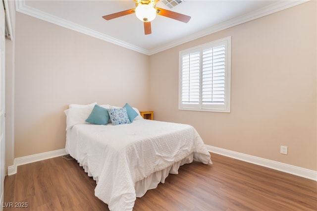 bedroom with crown molding, wood finished floors, baseboards, and ceiling fan