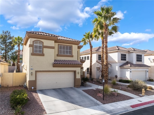 mediterranean / spanish-style house with fence, a tiled roof, concrete driveway, stucco siding, and an attached garage