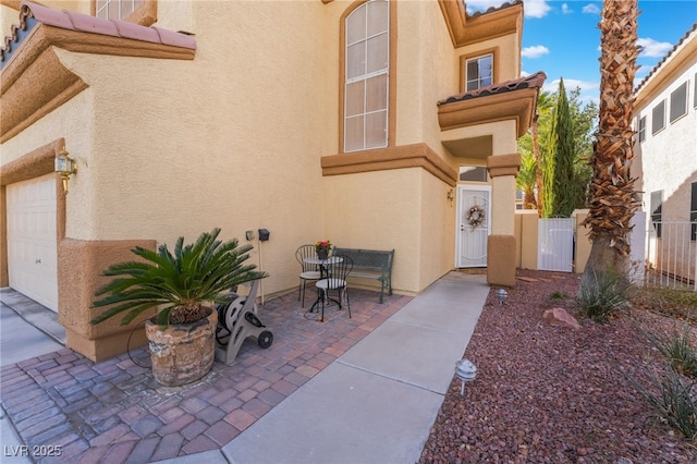 doorway to property featuring a patio, fence, and stucco siding