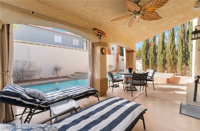 view of patio / terrace featuring a ceiling fan, outdoor dining area, a fenced backyard, and an outdoor pool