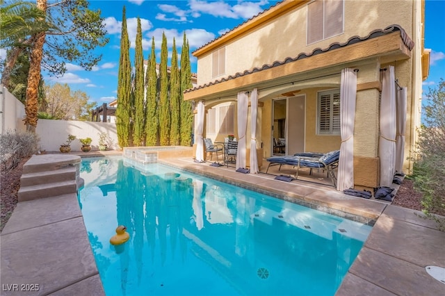 back of property with a patio area, a fenced backyard, a fenced in pool, and stucco siding