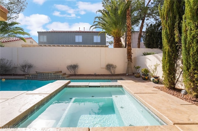 view of swimming pool with a pool with connected hot tub and a fenced backyard