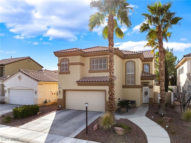 mediterranean / spanish house featuring stucco siding, a tile roof, fence, concrete driveway, and an attached garage