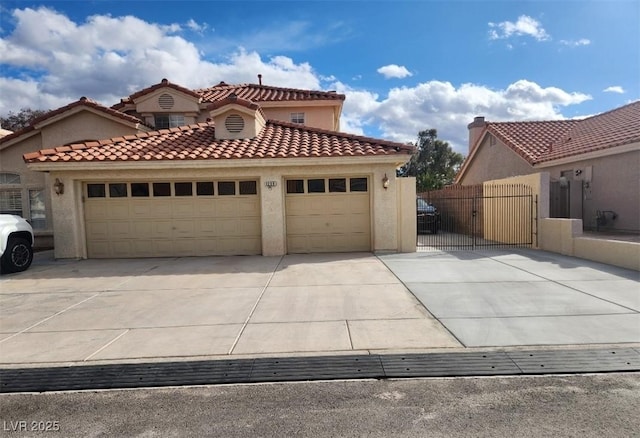 view of front of home featuring a gate, stucco siding, concrete driveway, a garage, and a tiled roof