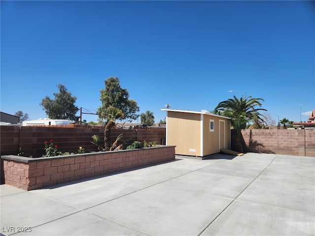 view of patio / terrace featuring a fenced backyard, a shed, and an outbuilding