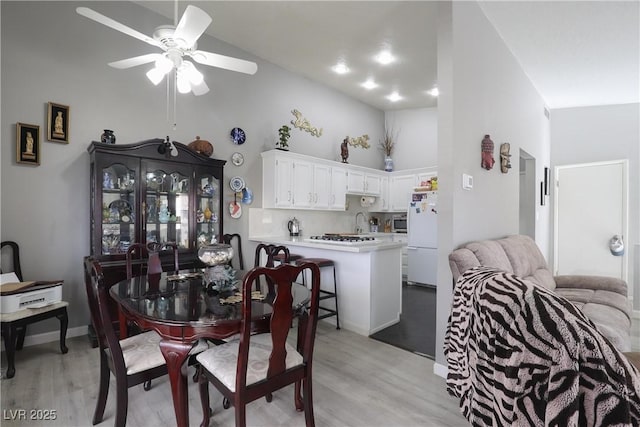 dining space with ceiling fan and light wood-style flooring