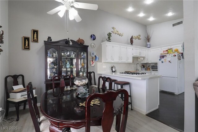 dining area with visible vents, light wood-type flooring, and ceiling fan