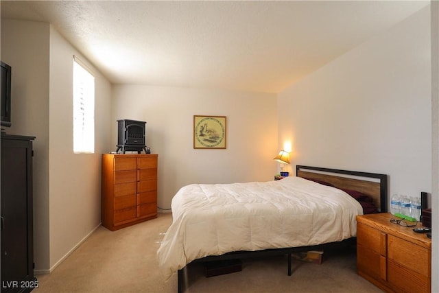 bedroom featuring baseboards and light colored carpet